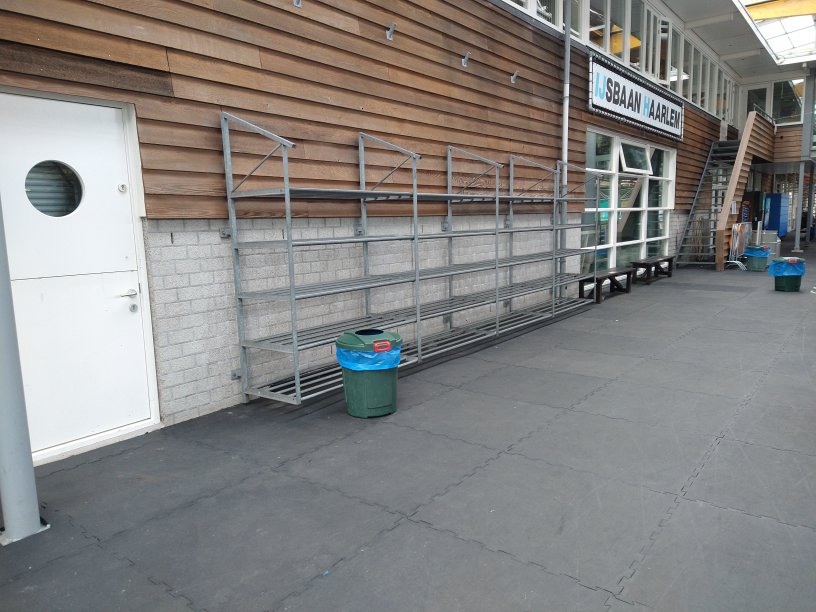 Foto van de kledingrekken waar schaatsers hun sporttrassen in kunnen plaatsen. Voor kostbaarheden zijn er lockers beschikbaar. Je kunt je tas ook in de kleedkamers onder de banken plaatsen.