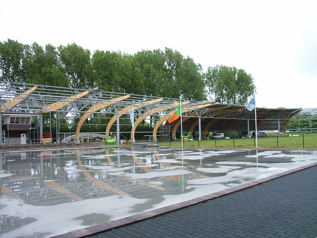Bouw van de galerijoverkapping op de IJsbaan Haarlem. Op de voorgrond het middenterrein voor de 30x60meterbaan.